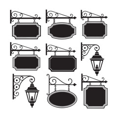 Collection of nine black wrought iron hanging signs and lanterns on white background street lamp