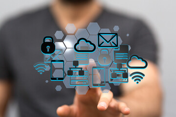 Image depicts a person interacting with a network of digital icons representing cloud computing,...