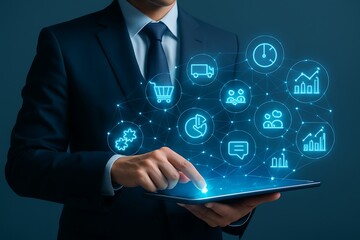 Businessman managing an integrated digital business with a tablet showing icons for crm, erp, automation, and analytics.