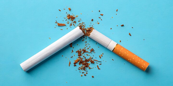 Broken Cigarette on a Blue Background. Stop Smoking Concept