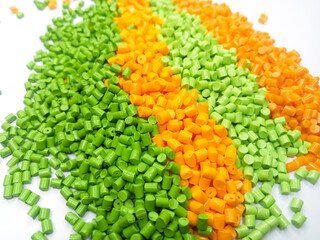 Various colors of masterbatch granules, polymer carrying resin and pigment poured in a white background, suitable for product catalog design of industrial plastic manufacturing company profiles