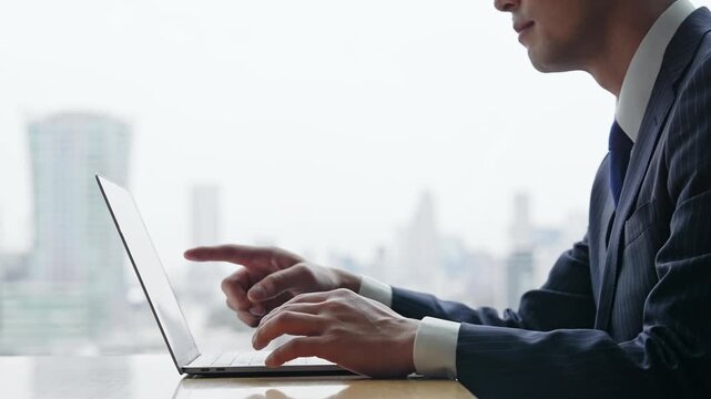 Male business person using laptop in urban office building