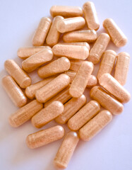 Close-up of vitamin C capsule supplement on white background.
