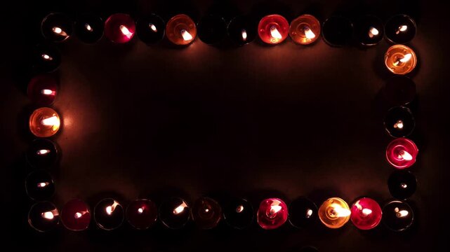 Burning candles against full dark background with copy space. Candles are used on occasions such as birthdays, weddings, festivals, prayers, and memorials to create light, symbolize devotion