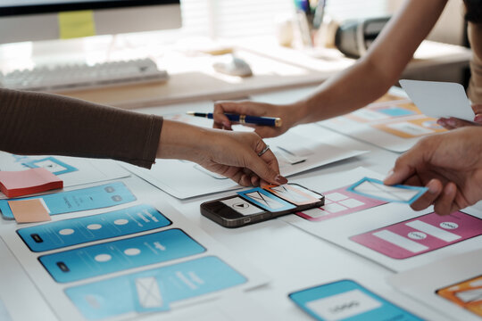 User experience designers collaborating on a fresh mobile application template, focusing on innovative strategies and effective user interface design