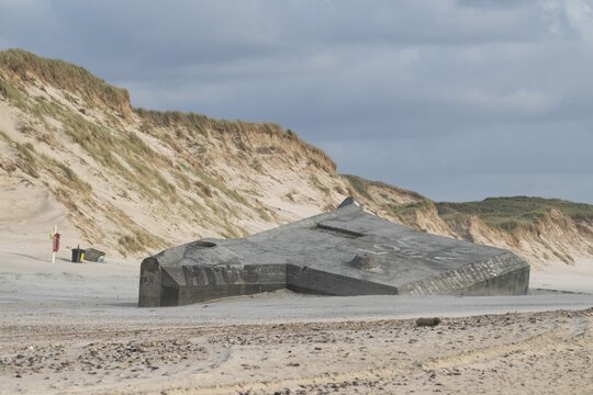 Abandoned bunker from the 2nd World War, sunken into the sand with graffiti, surrounded by sand dunes, beach near Hvide Sande, North Sea, Denmark