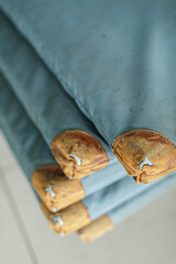 High-quality photo of stacked vintage teal canvas bags, showcasing unique leather patches. Ideal for travel, vintage, and texture themes.