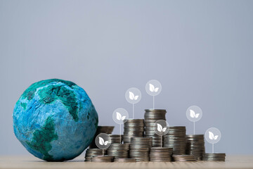 A globe and stacks of coins with leaf icons symbolize sustainable investment and eco-friendly finance.