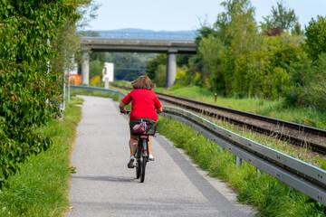 Frau auf Rad am Radweg dem neben einem Bahngleis