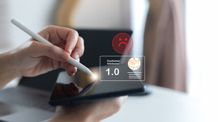 Using a stylus on a tablet with a hologram showing customer satisfaction rating 1.0 and a sad face icon. Concept of negative review, poor service, dissatisfaction, feedback management,