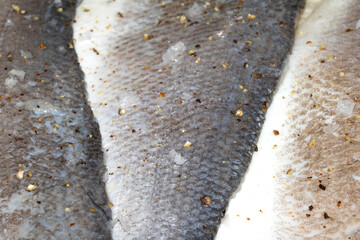 Macro close up of raw basa fish skin with scale detail ready for cooking © squeebcreative
