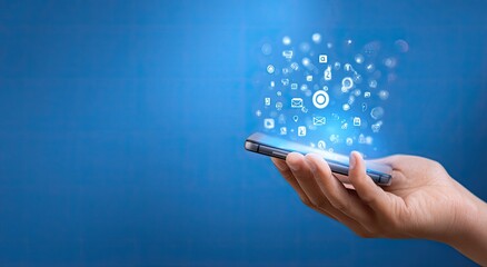 Hand holding a smartphone with digital icons emanating