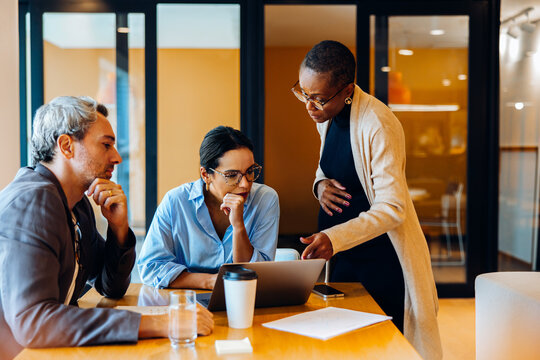Group of colleagues discussing work at a table in a professional setting