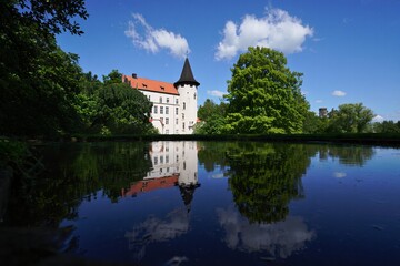 Obraz premium White castle reflected in calm water under a blue sky