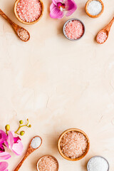Obraz na płótnie Canvas Beauty spa therapy cosmetics and wellness flat lay - sea salt in many bowls with flowers, top view