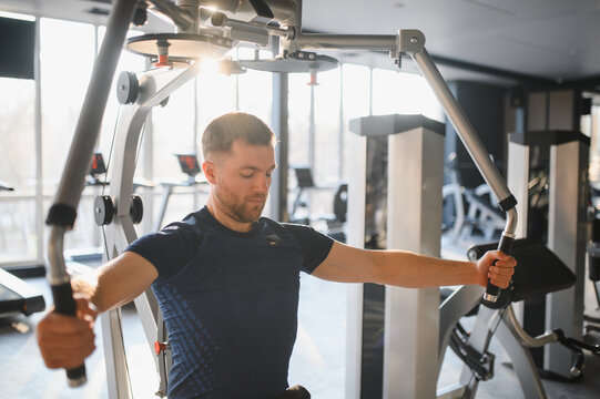 Man doing pec deck fly exercise in rehabilitation gym