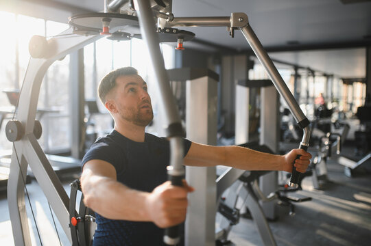 Man exercising with cable machine in gym for rehabilitation and sports training