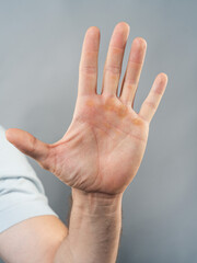 Male Hand Palm Close-Up on Gray Background, Open Gesture
