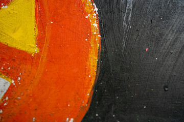 Abstract close-up of vibrant orange and deep black paint textures.