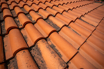 Close-up of red ceramic roof tiles in an old Mediterranean town. Traditional roofing, architecture, and construction texture.
