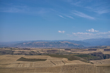 Expansive Rural Landscape Under a Vast Blue Sky with Wispy Clouds