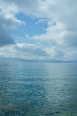 Obraz premium A Serene Ocean Vista with Wispy Clouds Above a Tranquil Water Surface Under the Bright Sky