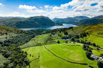 Naklejka premium Rural landscape of the English Lake District with farmland, hills, and Ullswater