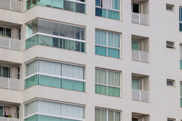 Prédio residencial moderno com janelas grandes e varandas amplas. 