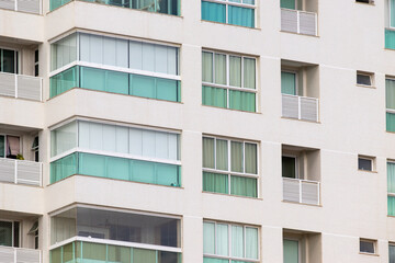 Prédio residencial moderno com janelas grandes e varandas amplas. 