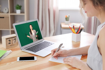 E-learning concept. Student having online video chat with teacher via laptop at desk, closeup