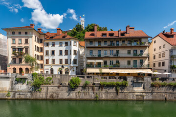 Picturesque buildings on the banks of the river that passes through the capital of Slovenia with its castle in the background, Ljubljana.