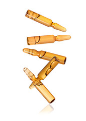 Many glass ampoules falling on white background