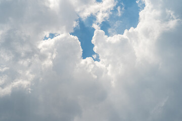 Fluffy white clouds with a glimpse of blue sky.