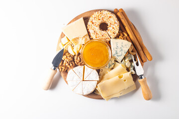 Wooden charcuterie board with various cheese and olives. Brie. Camembert. Parmesan, feta, blue cheese. Italian, French cheese