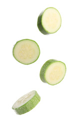 Fresh zucchini slices falling on white background