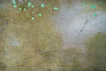 Textured concrete surface with green paint splatters.