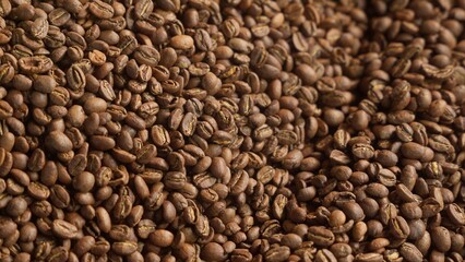 Close up roasted coffee beans mixing in mixer roaster blend automatic metal drum machine stirring roasting cocoa caffeine at production facility aromatic grains in grinder industrial food preparation