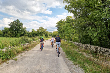 Family cycling together on rural Karst road