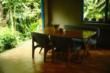 Cozy Dining Corner with wooden table and cushioned chairs opens to a garden view
