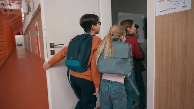 Back view four multiracial children running in school group of active diverse kids classmates little friends run in corridor hurrying to class come in classroom elementary education friendship concept