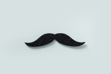 Black moustache isolated on blue background. Creative concept for Father Day. Moustache month and...