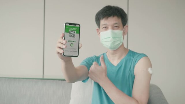 A person wearing a mask shows a smartphone with a vaccination QR code, symbolizing health and safety measures amidst the ongoing pandemic.