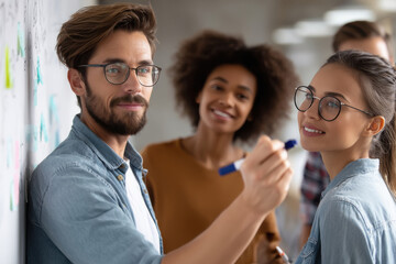 Startup indian team brainstorming ideas on a whiteboard in a modern office