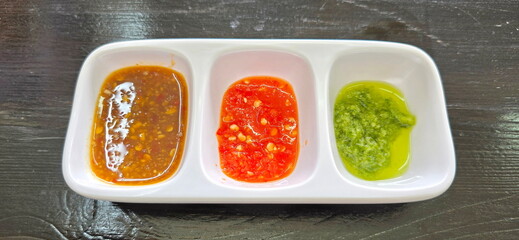 Green:spicy seafood sauce. Orange:sweet-slightly spicy sauce. Brown:sweet and salty bean paste sauce. Plastic cups are divided into three types of dipping sauce. steamed food, steam rice with chicken
