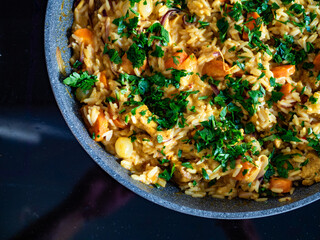 Chicken curry with vegetables and white rice in frying pan on induction cooker