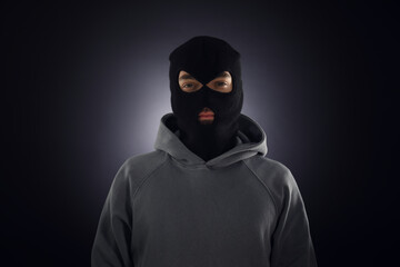 Criminal man in mask on dark background