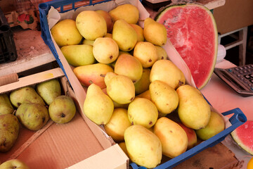 Fresh harvest of ripe pears at a vibrant market stall in summer