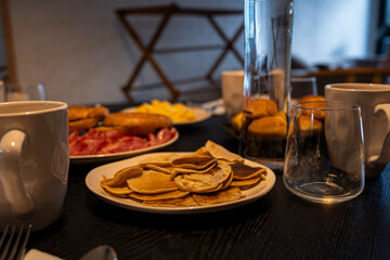 A table with a plate of food and a glass of water. The table is set for a meal