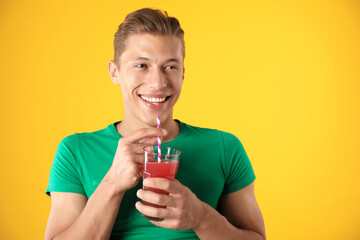 Man with juice and drinking straw on orange background