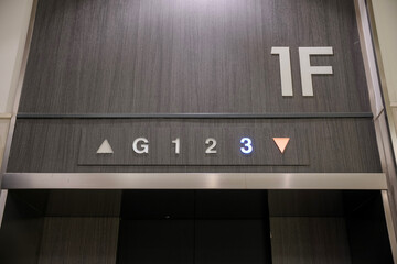 An elevator on the 1st floor shows floor indicator with light on 3 and a red down arrow.